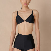 Woman wearing a black triangle bikini top with adjustable straps and removable cups, paired with matching bottoms made with sustainable swimwear fabrics.